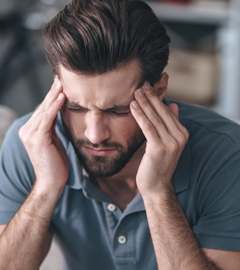 Man holding his head and temples in discomfort