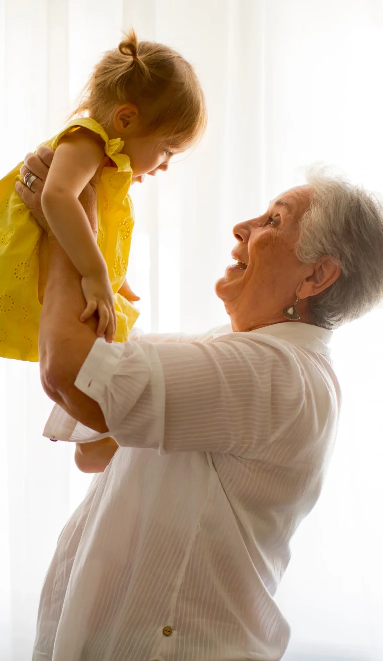 Smiling older woman holding a young child