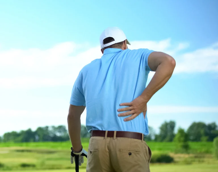 Man experiencing back pain while golfing