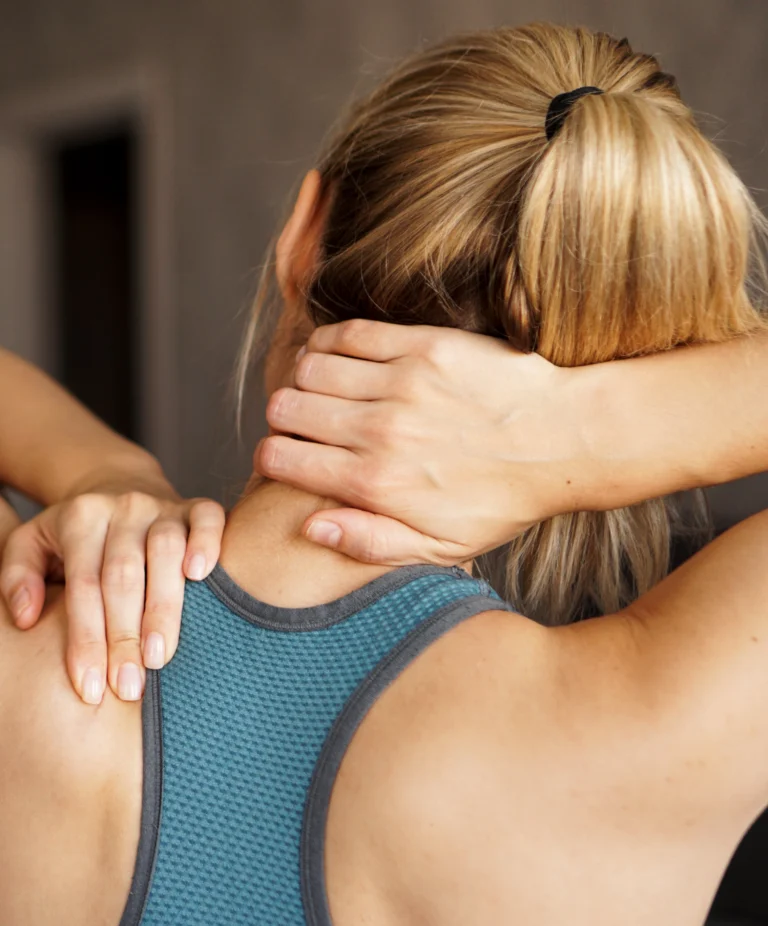 Woman rubbing her neck and shoulder in discomfort